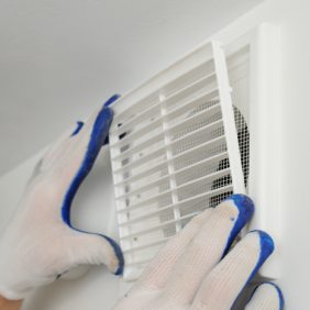 Worker installs ventilation grille.